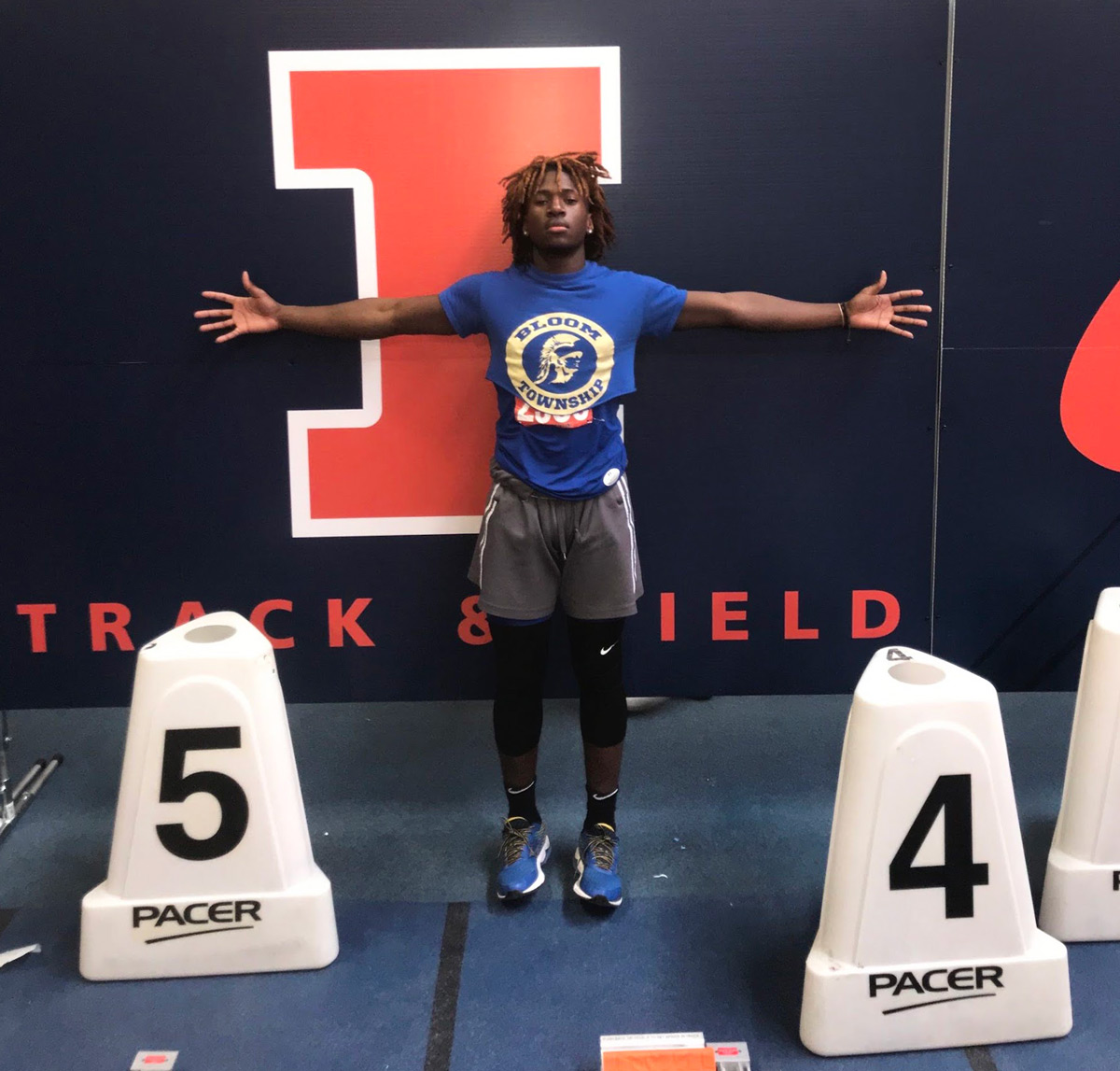 Samuel, arms outstretched, representing Illinois Track & Field