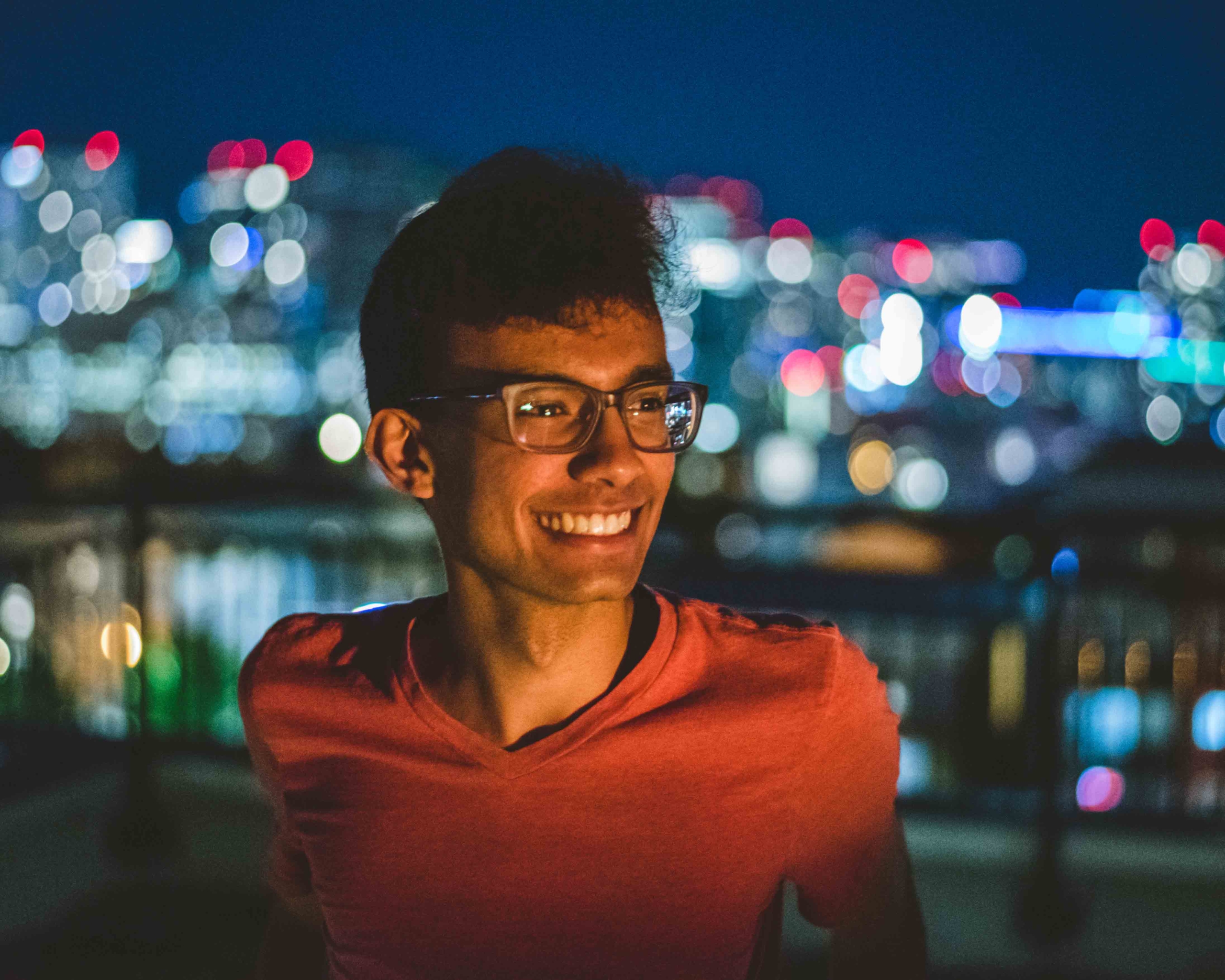 Arpan, a Hack4Impact co-director, smiling in front of city lights.